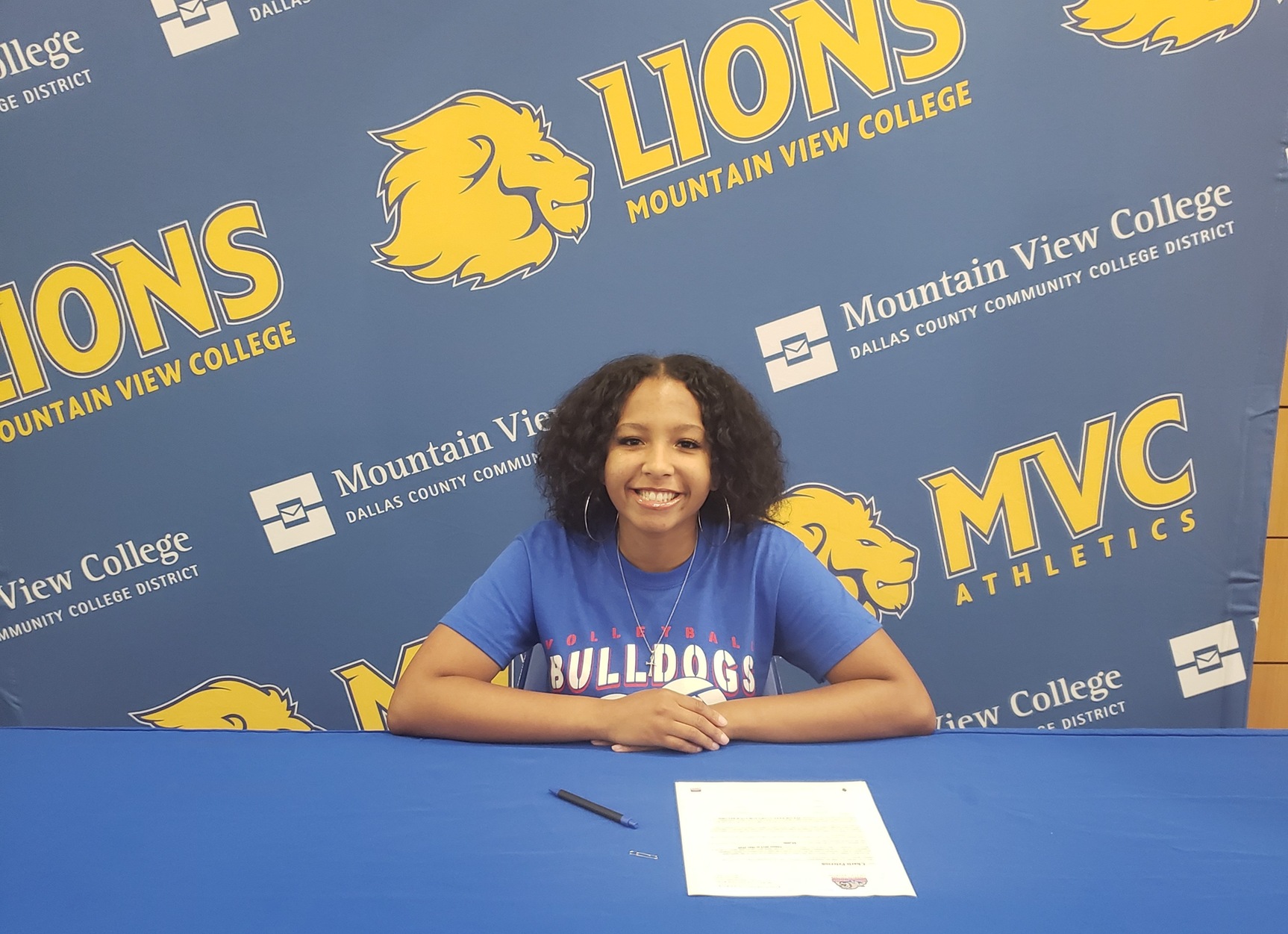 Charis Peterson smiling as she signs letter of intent.